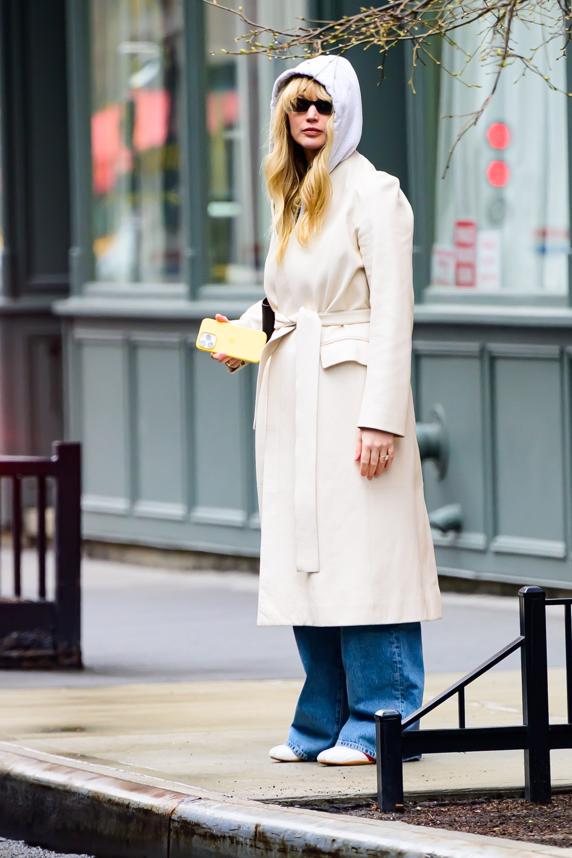 Jennifer Lawrence wearing a long coat and Adidas Tokyo sneakers