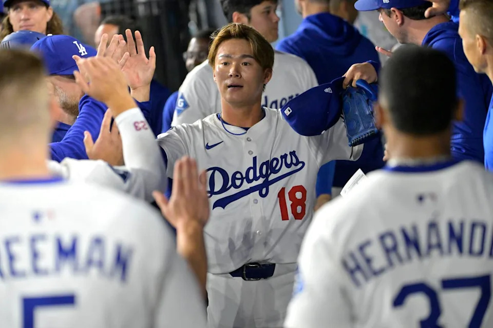 Dodgers starting pitcher Yoshinobu Yamamoto celebrates with teammates in the dugout following the sixth inning