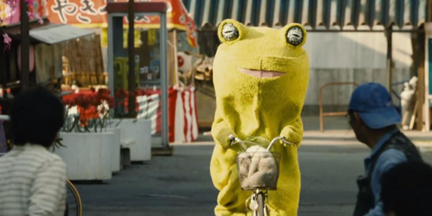 A person dressed in a frog costume is arriving on a bicycle with a backpack attached to the front in Yakuza Apocalypse