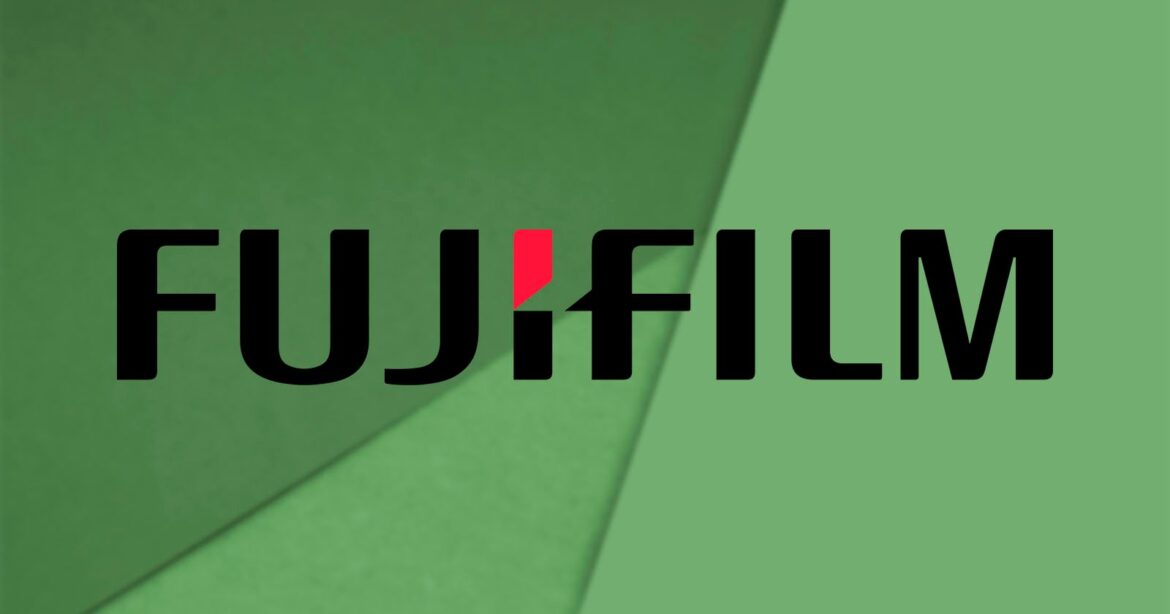 The image displays the Fujifilm logo on a green geometric background. The logo features the word "Fujifilm" in bold black letters, with a red accent on the letter "i.