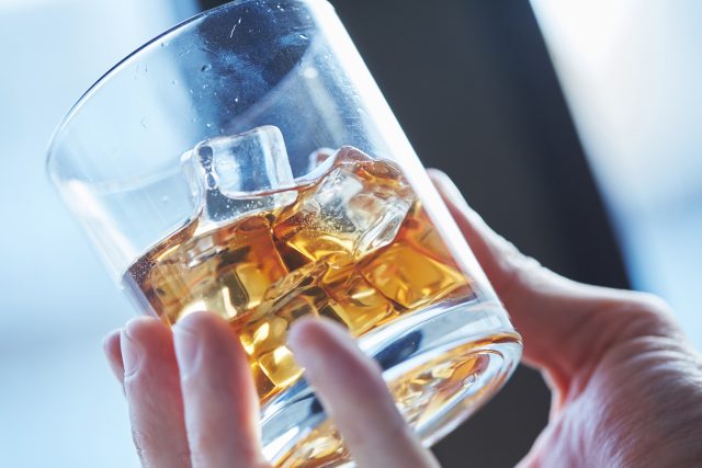 Is Japanese whisky struggling to fight fakes? - glass of whiskey with ice in his hand
