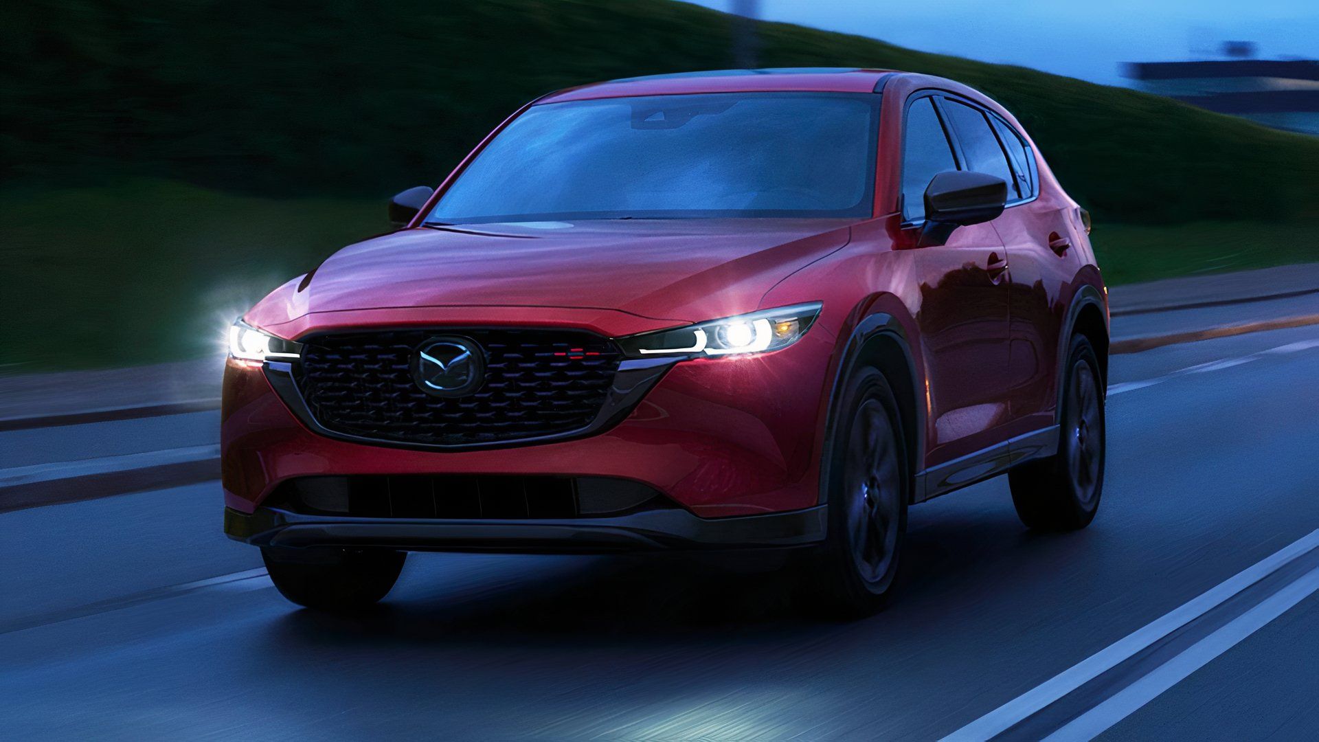 2025 Mazda CX-5 in red driving on road at night