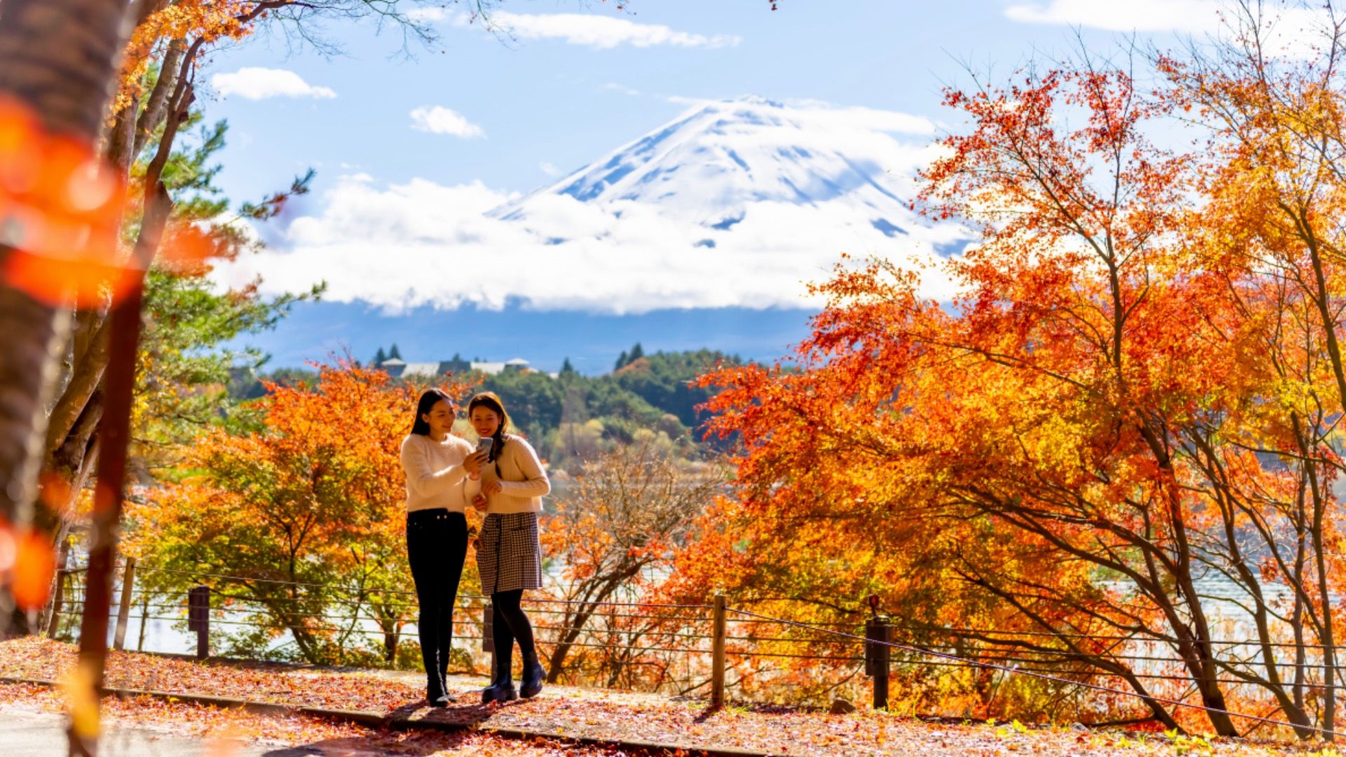 Women pose for photo in front of Mt. Fuji, Japan