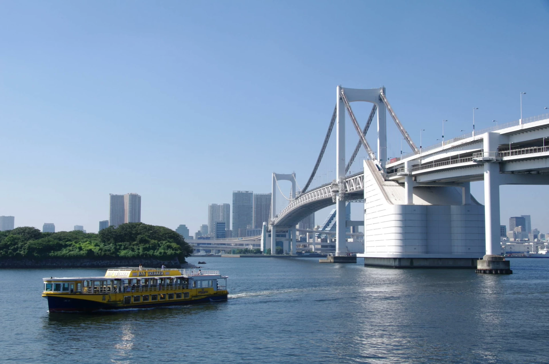 A tour boat on the water near the Rainbow Bridge to Odaiba island.
