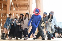 A visitor to the 2025 World Expo in Osaka dressed as the official mascot Myaku-Myaku joins people for a commemorative photo, at the Expo venue in Osaka's Konohana Ward on April 25, 2025. (Mainichi/Takehiko Onishi) 