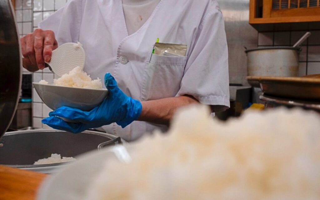 An employee prepares a bowl of rice at a restaurant in Tokyo.