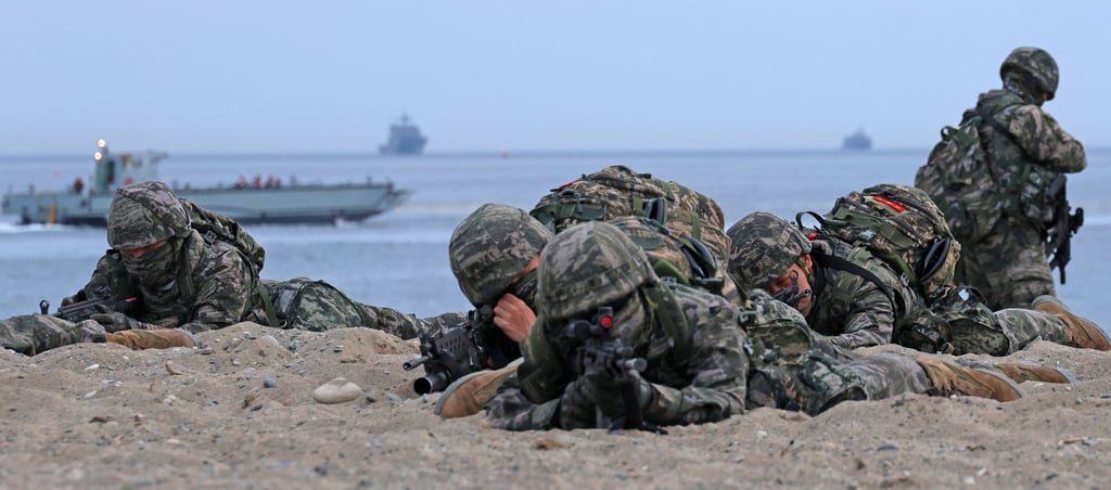 South Korean marines take aim with their rifles after dashing out of an assault amphibious vehicle during a landing drill in Pohang, North Gyeongsang province, on April 28. Photo: EPA-EFE/Yonhap