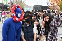 A visitor to the 2025 World Expo in Osaka dressed as the official mascot Myaku-Myaku joins people for a commemorative photo, at the Expo venue in Osaka's Konohana Ward on April 25, 2025. (Mainichi/Takehiko Onishi) 