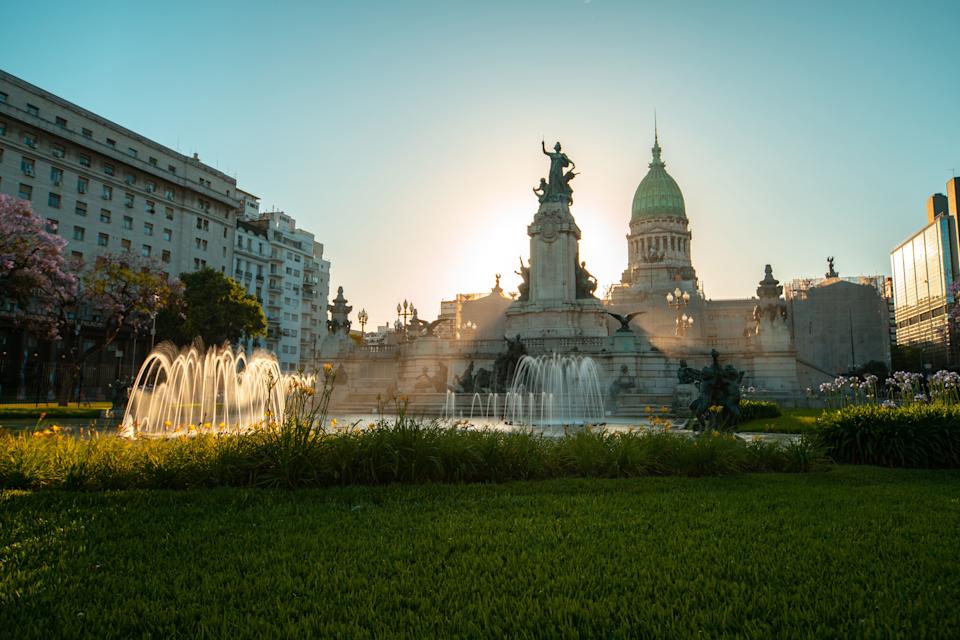 A sunlit view of monument of the Two Congresses with the Palace of Congress on Congressional Plaza in Buenos Aires, Argentina.