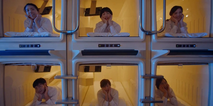 People posing a picture with their designated capsules at a capsule hotel