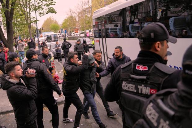 A union member is detained by Turkish police officers
