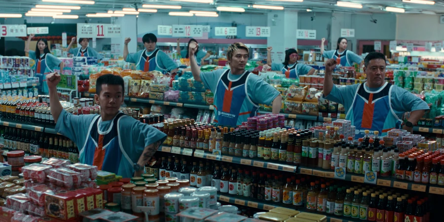 A group of people dancing and posing inside the supermarket