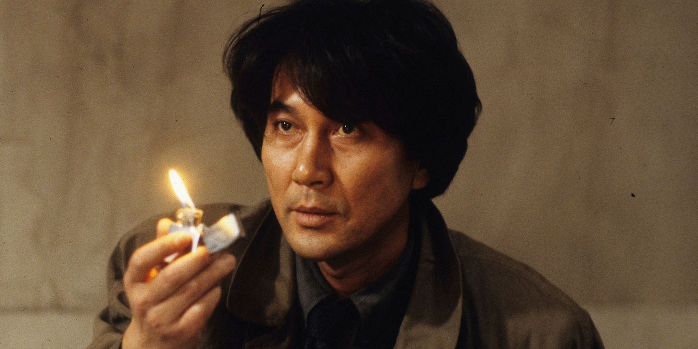 Kōji Yakusho holding a lighter in Cure.
