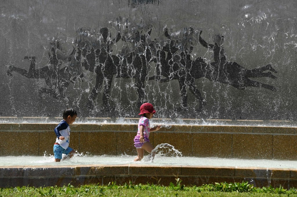 Children play in a water fountain in a Tokyo park, as a heatwave grips Japan in July 2018. Japan faces potential outdoor sports bans for children by 2060 due to soaring summer temperatures. Photo: AFP
