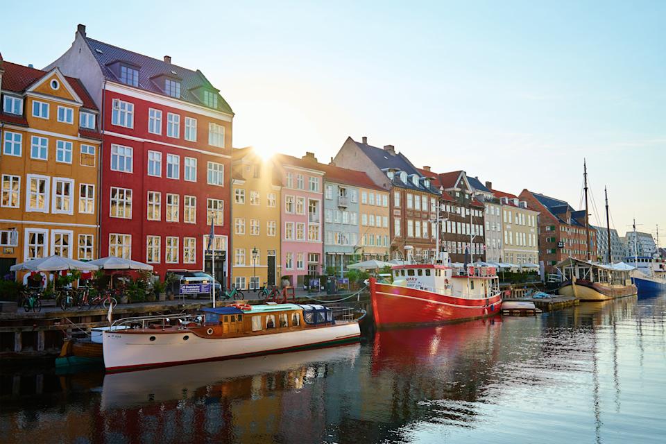 A colorful canal is buzzy with small boats in Copenhagen, Denmark