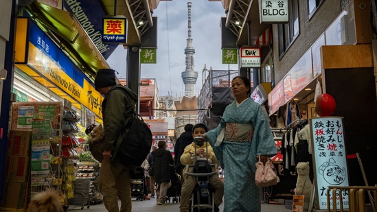 This picture taken on February 21, 2025 shows people walking past shops in the Asakusa area as the 634m-high (2,080 ft.) (AFP)