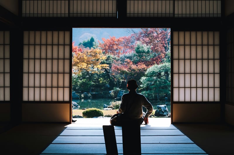 Man sitting by shoji doors at 
Tenryu-ji Temple, Kyōto-shi, Japan