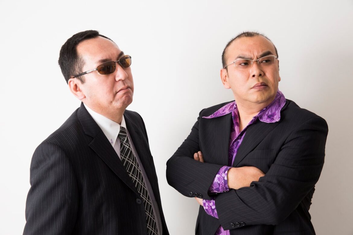 Yakuza style guys, both in suits and glasses and one with a purple shirt