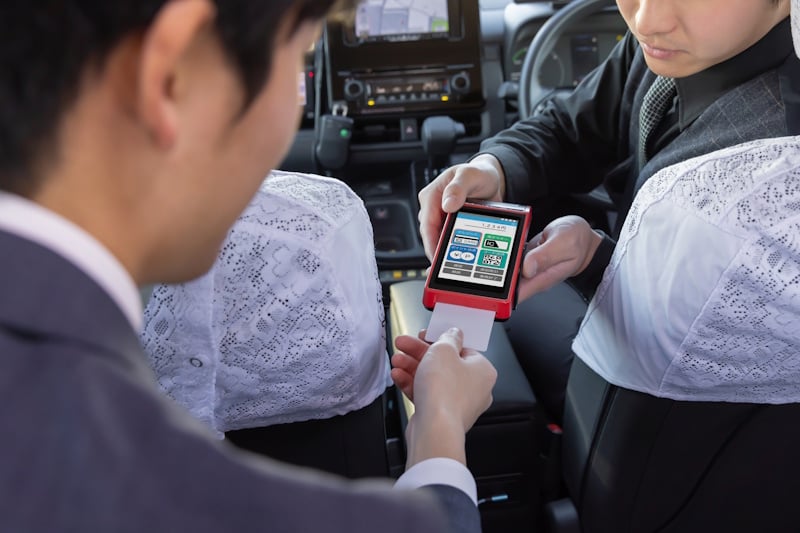 A business man paying for a taxi ride with a credit card