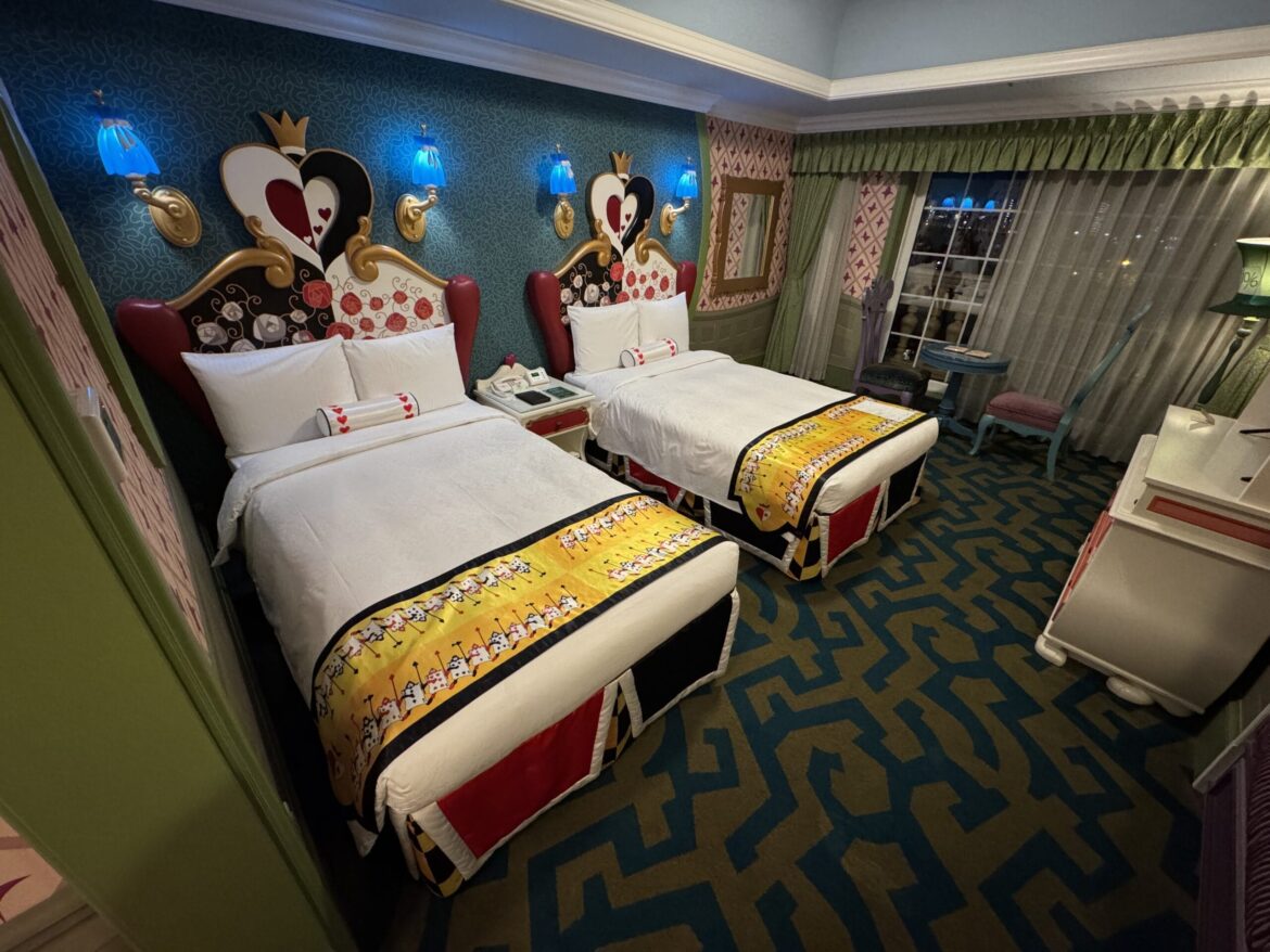 A closed white door with blue panels and green trim, like an Alice in Wonderland hotel room at Tokyo Disneyland Hotel.