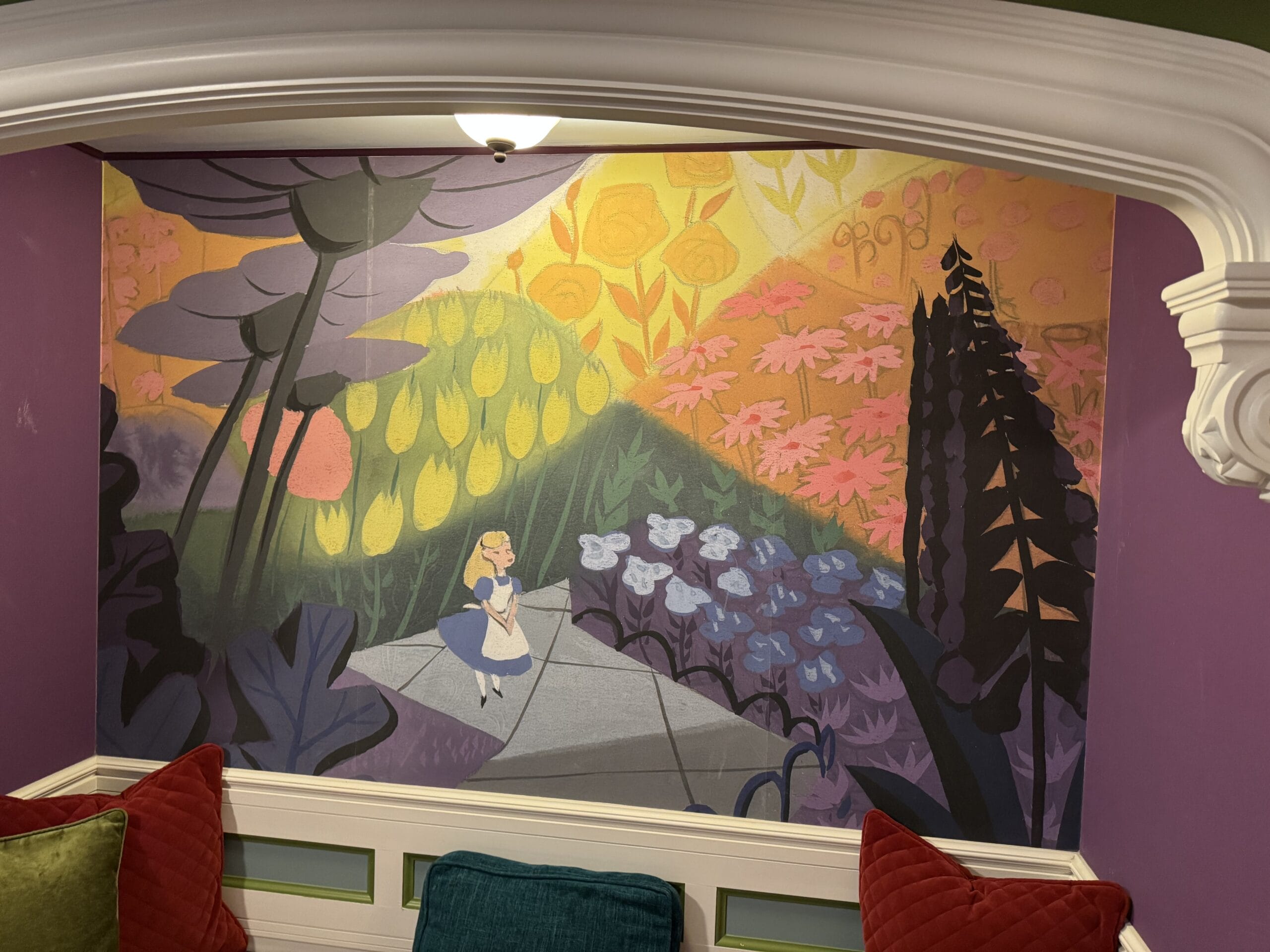 A mural in the Alice in Wonderland Hotel Room at Tokyo Disneyland Hotel shows Alice strolling through a whimsical, colorful garden.