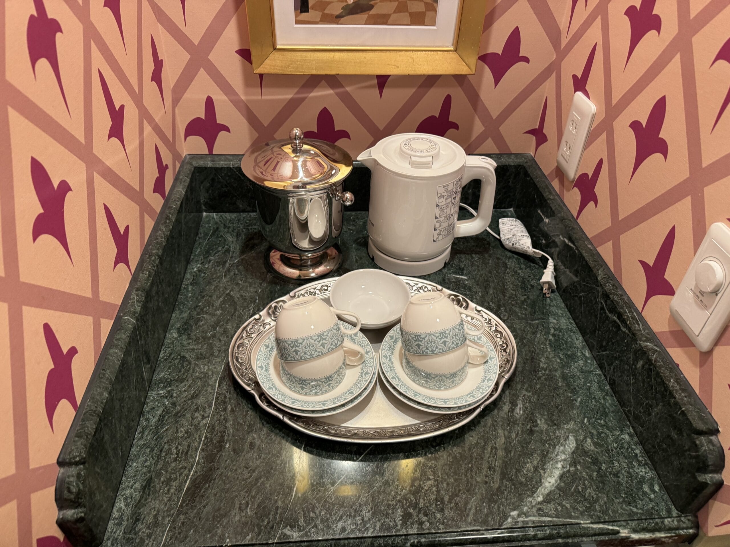 Two teacups, saucers, and a teapot on marble evoke an Alice in Wonderland Hotel Room at Tokyo Disneyland Hotel.