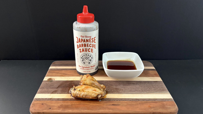 Bachan's Hot Honey Japanese Barbecue Sauce on wooden cutting board with wings and ramekin