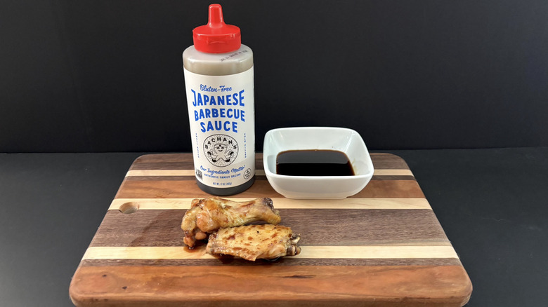 Bachan's Gluten Free Japanese Barbecue Sauce on wooden cutting board with wings and ramekin