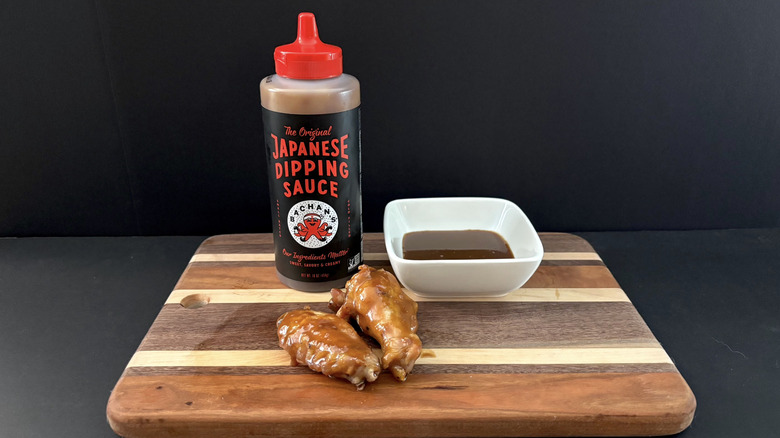 Bachan's The Original Japanese Dipping Sauce on wooden cutting board with wings and ramekin