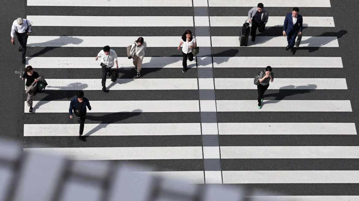 Aerial view of pedestrians crossing a street near Tokyo Station in Tokyo, Japan.