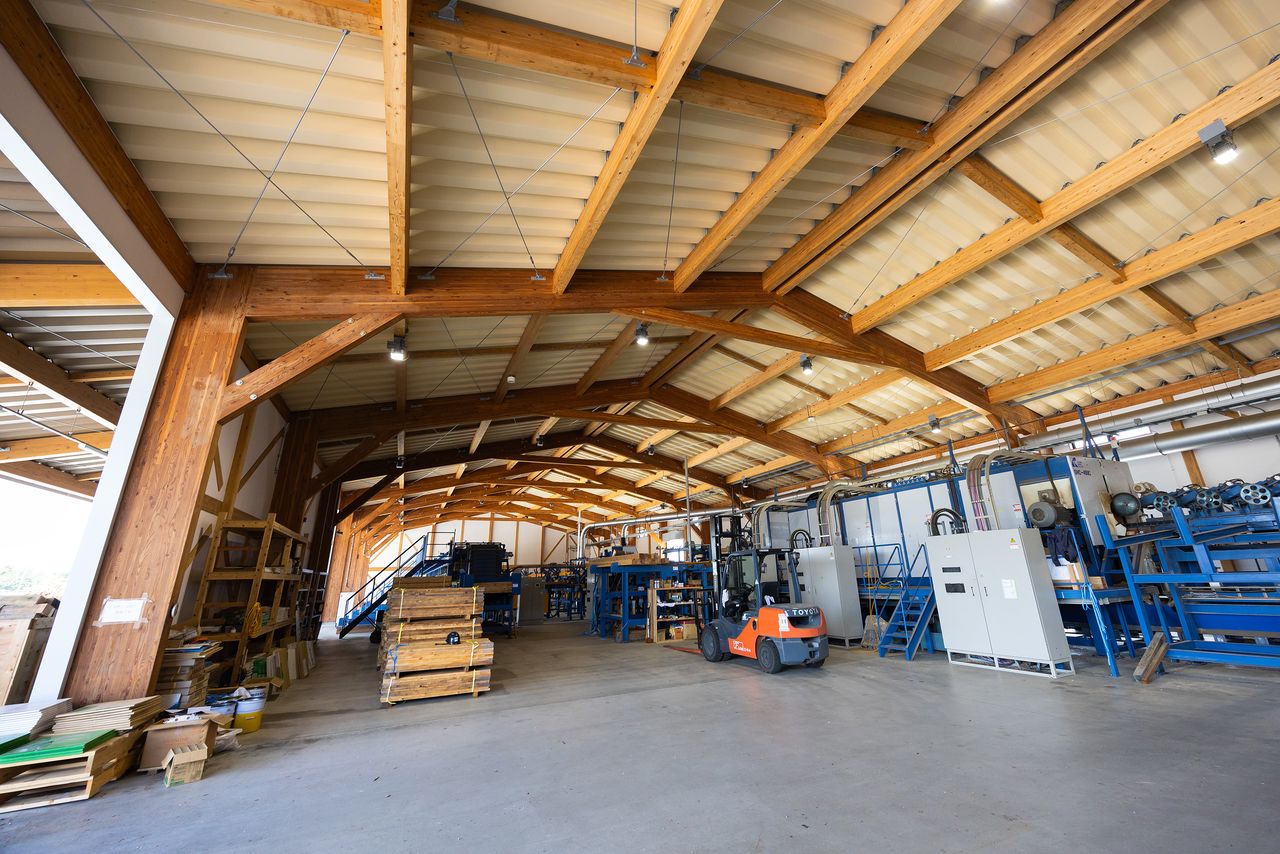 Thick, laminated structural timber has been used for the columns and beams in the building that houses the plant’s lumber facility. (© Nippon.com)