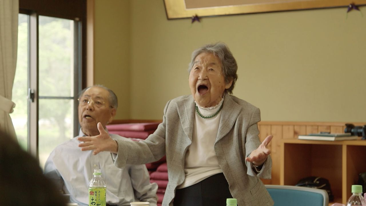 Tetsuyo sings a graduation song for former students. (© 104-Hitori Production Committee)