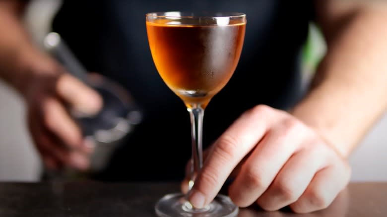 A bartender serves a Nippon cocktail