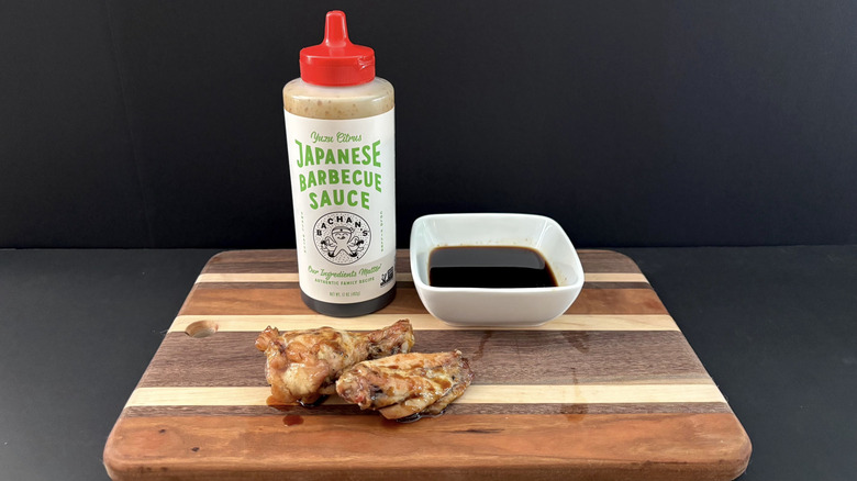 Bachan's Yuzu Citrus Japanese Barbecue Sauce on wooden cutting board with wings and ramekin