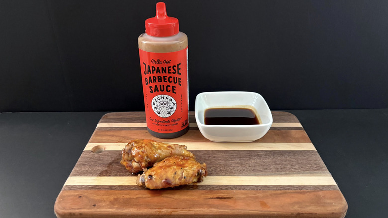Bachan's Hella Hot Japanese Barbecue Sauce on wooden cutting board with wings and ramekin