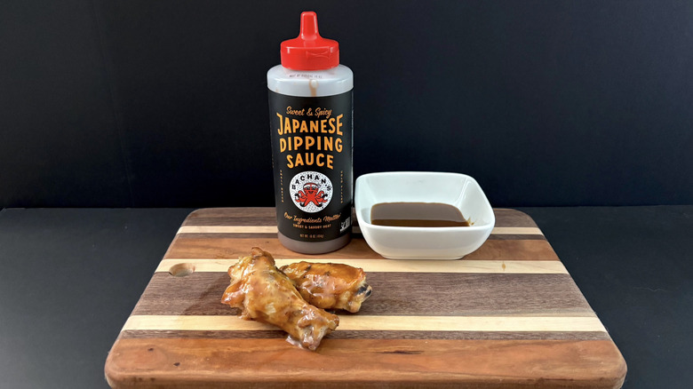 Bachan's Sweet & Spicy Japanese Dipping Sauce on wooden cutting board with wings and ramekin