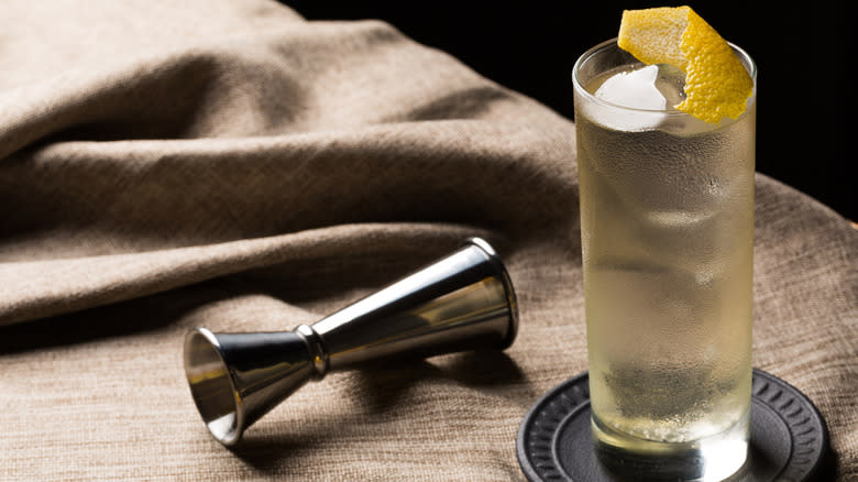 A Japanese Highball cocktail sits next to a cocktail jigger