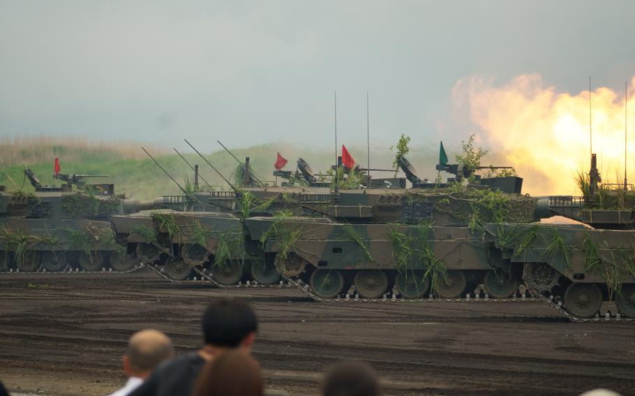 Japan Ground Self-Defense Force tanks perform live-fire drills in front of spectators.
