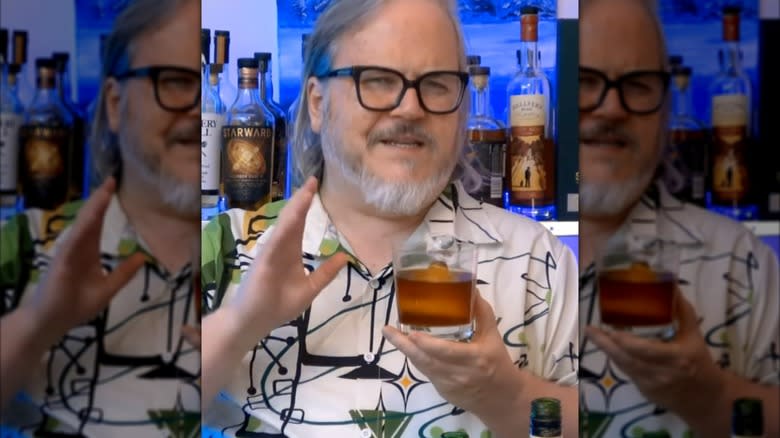 A man holds a long look back cocktail