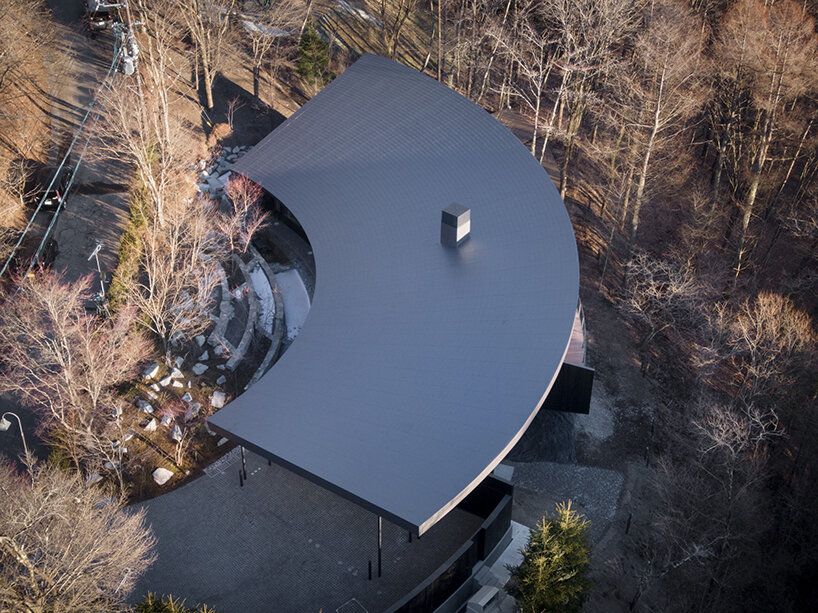 kamiya architects' residence–hotel hybrid traces sweeping arc through the japanese forest