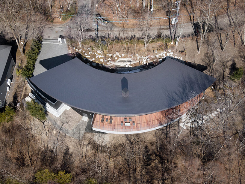 kamiya architects' residence–hotel hybrid traces sweeping arc through the japanese forest