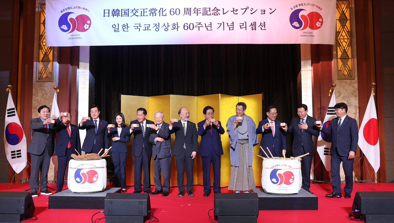Participants raise a toast and pose for a commemorative photo during a ceremony marking the 60th anniversary of diplomatic normalization between Korea and Japan, held at Lotte Hotel in Seoul on Monday. (Yonhap)
