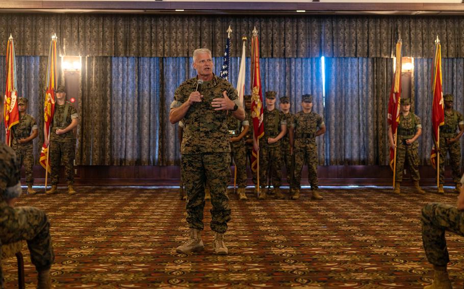 A man speaks during a ceremony in a room.