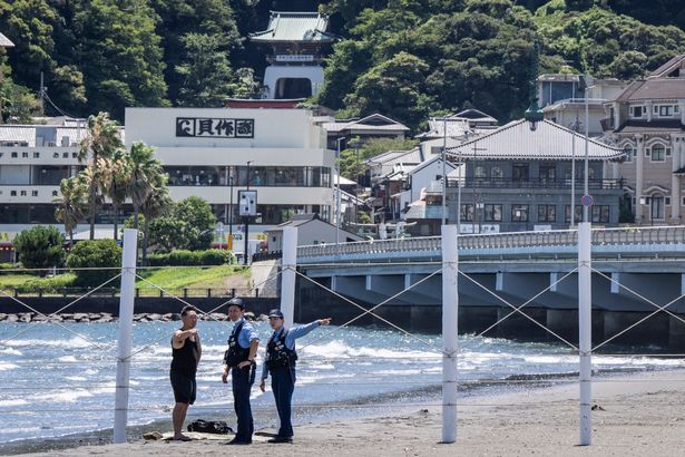Police evacuating a beachgoer in Japan