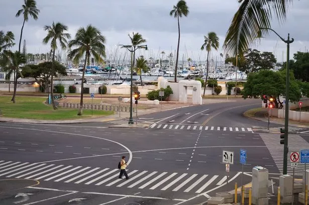 A pedestrian crosses and empty Ala Moana Boulevard ahead of an anticipated tsunami on July 29, 2025 in Honolulu, Hawaii