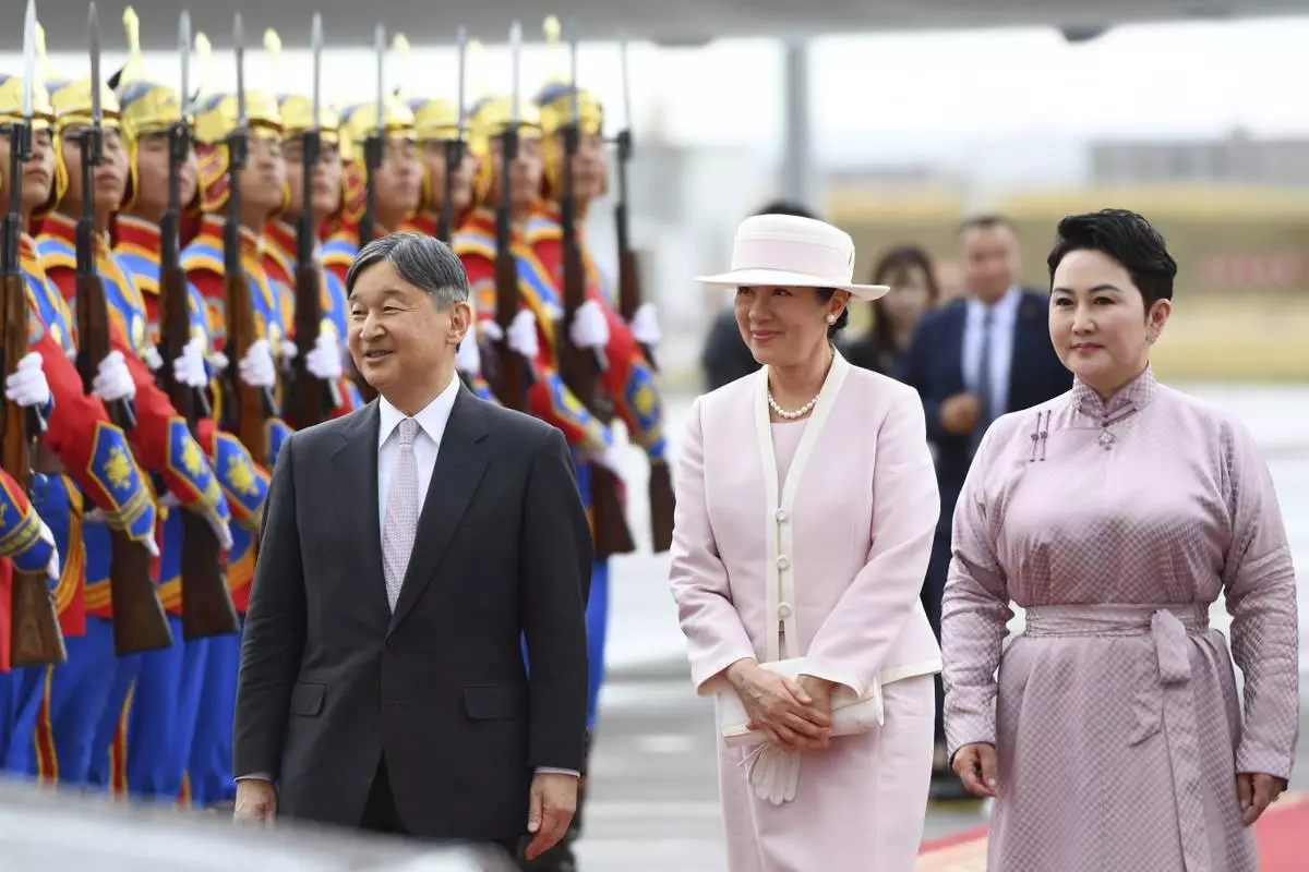 Japanese Emperor Naruhito, left, and Empress Masako, walk with Mongolian Foreign Minister Batmunkh Battsetseg, right, after arriving at the Chinggis Khaan International Airport near Ulaanbaatar, Mongolia on Sunday, July 6, 2025. (MONTSAME News Agency via AP)
