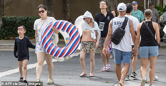People cross a street as they depart from the beach in Oahu, Hawaii on July 29, 2025, after an 8.7 earthquake off of Russia's far east prompted tsunami alerts. A powerful 8.7 magnitude earthquake off Russia's far east has prompted tsunami alerts across parts of the Pacific including Japan, Hawaii, Russia and Ecuador, and warnings along the California coast, US authorities said late on July 29. The massive temblor triggered warnings of waves up to three metres (10 feet) possibly hitting the coasts of Russia, Hawaii and even Ecuador and Chile along South America's west coast, according to the US Pacific Tsunami Warning Center based in Honolulu, Hawaii. (Photo by Eugene Tanner / AFP) (Photo by EUGENE TANNER/AFP via Getty Images)