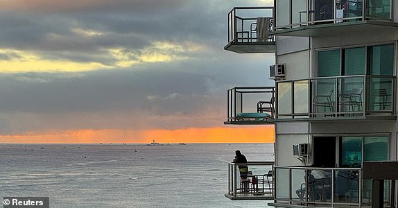Vacationers stand on balconies at the Aston Waikiki Circle Hotel looking towards Waikiki Beach after authorities warned of the possibility of tsunami waves, following an earthquake which earlier struck off Russia's Far Eastern Kamchatka Peninsula, in Honolulu, Hawaii, U.S. July 29, 2025.    REUTERS/Nicola Groom
