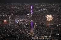 Fireworks are launched from two venues during the Sumida River Fireworks Festival in Tokyo on July 26, 2025, in this photo taken from a Mainichi Shimbun helicopter. Tokyo Skytree, center, is seen illuminated in purple. (Mainichi/Koichiro Tezuka) 