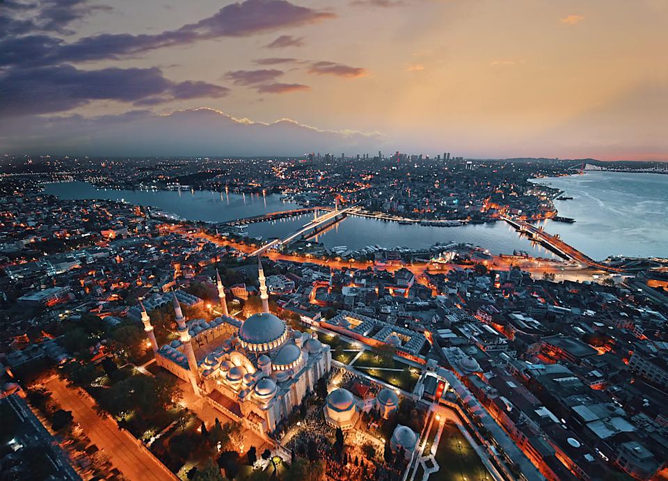 Aerial view of Istanbul at sunset, featuring the iconic Suleymaniye Mosque and the Bosporus, highlighting the city's vibrant landscape and waterways